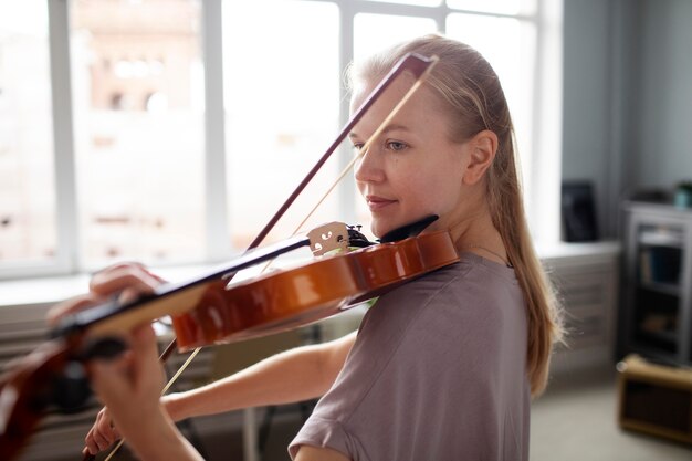 バイオリンのミディアムショットを演奏する女性