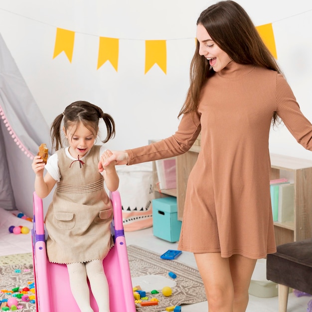 Woman playing with girl on slide