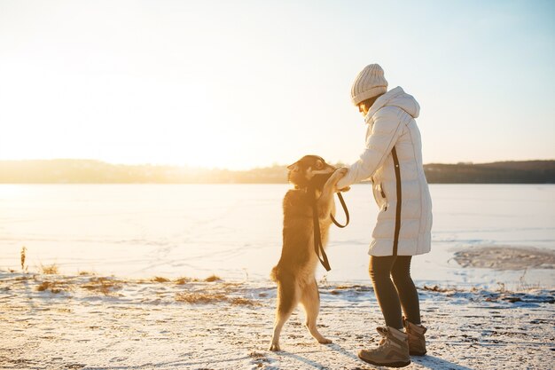 Woman playing with her dog on a winter day