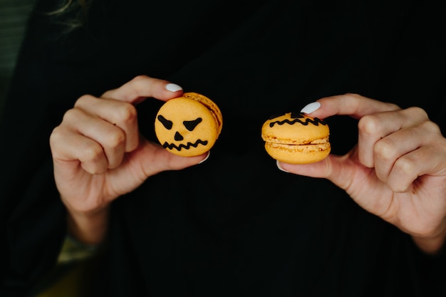 Woman playing with two halloween cookies