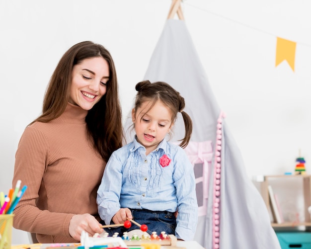 Woman playing with young girl at home