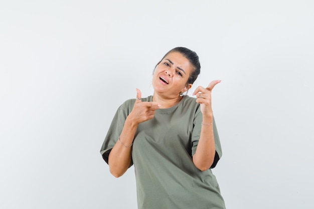 woman pointing aside in t-shirt and looking charming.