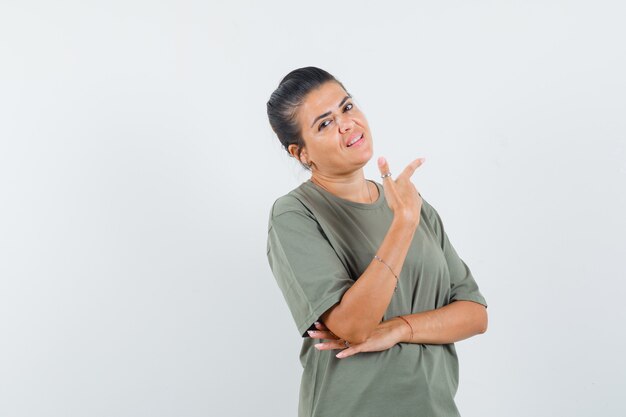 woman pointing aside in t-shirt and looking confident