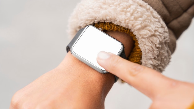 Foto gratuita donna che punta a uno smartwatch vuoto