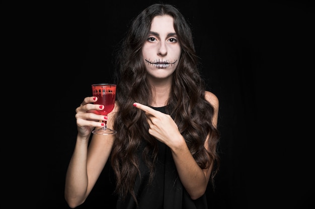 Woman pointing glass with red liquid