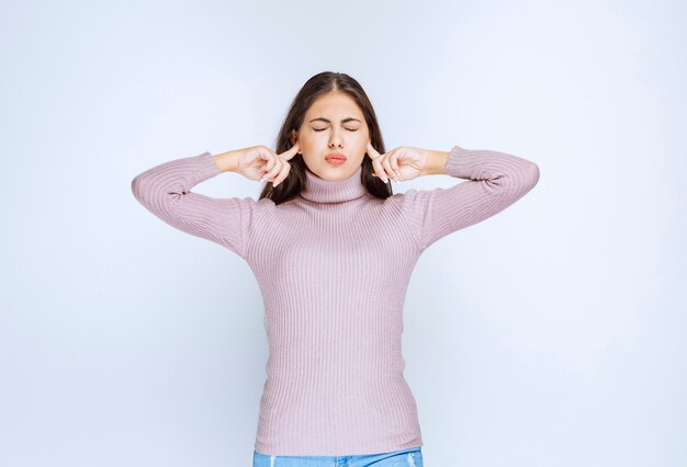 woman pointing her ear as she can not hear well.