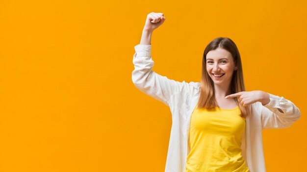 Woman pointing at her muscle