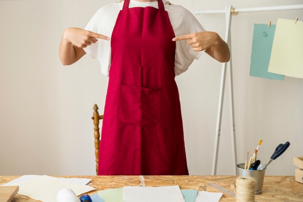 Woman pointing at her red apron