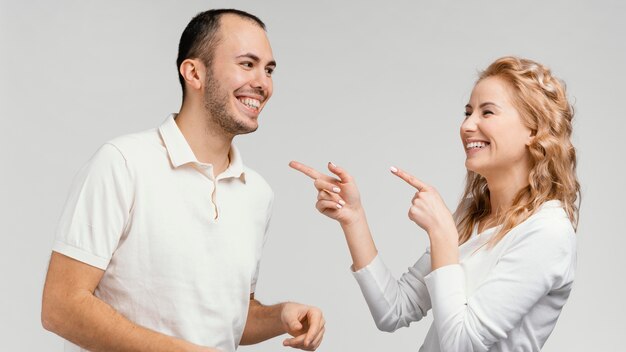 Woman pointing at man laughing