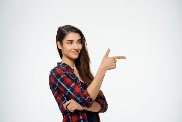 woman pointing right and smiling