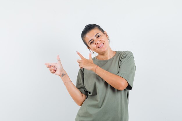 woman pointing to the side in t-shirt and looking confident
