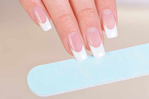 Free photo woman polishing fingernails on hand with nailfile