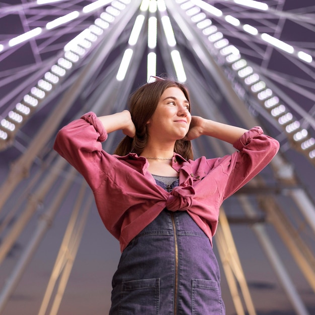 Woman posing at the amusement park next to big wheel