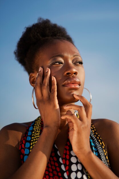 Woman posing in an arid environment while wearing native african clothing