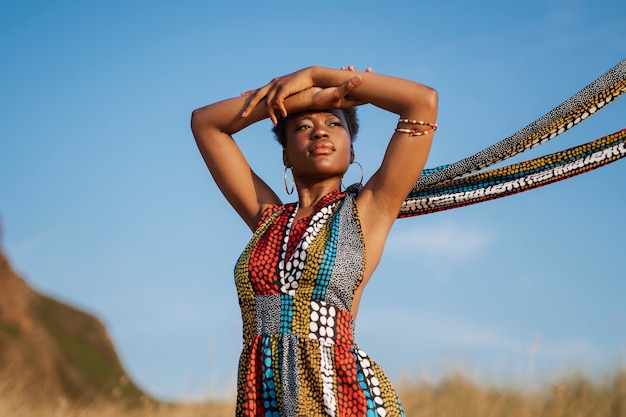 네이티브 아프리카 옷을 입고 건조한 환경에서 포즈를 취하는 여자