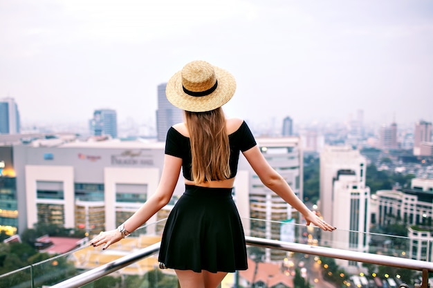 Woman posing back at roof top at luxury hotel in Bangkok