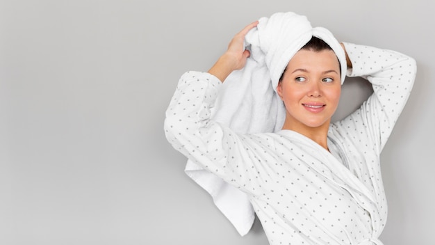 Free photo woman posing in bathrobe and towel with copy space