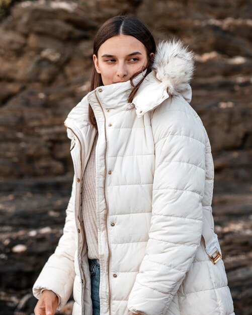 Woman posing at the beach with winter jacket