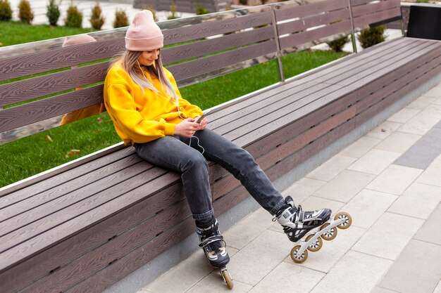 Woman posing on bench while wearing roller blades