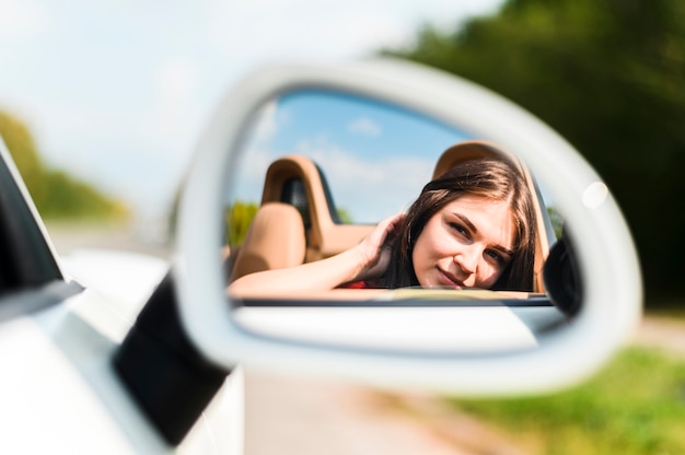 Free photo woman posing in car mirror