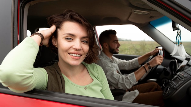 Free photo woman posing in car near boyfriend