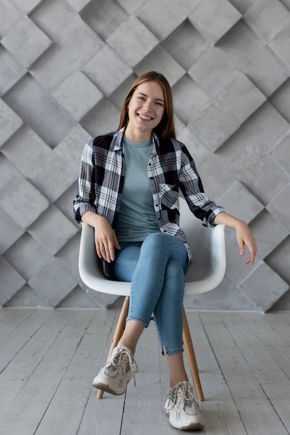 Free photo woman posing on a chair for the camera