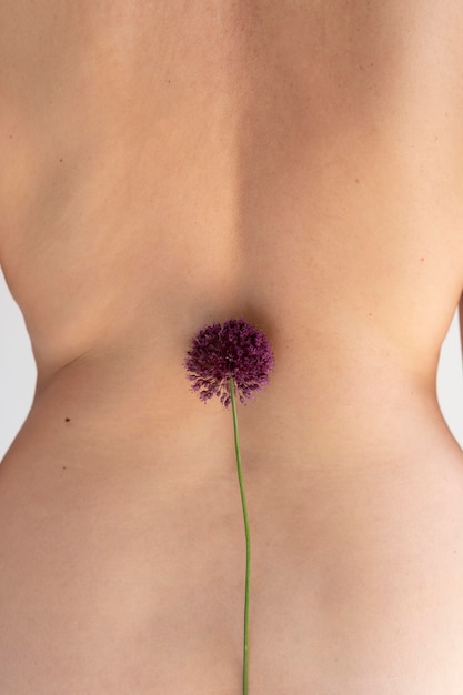 Foto gratuita donna che posa con sicurezza nuda e si mostra con un fiore