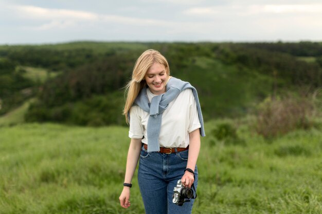 Woman posing in nature while holding camera