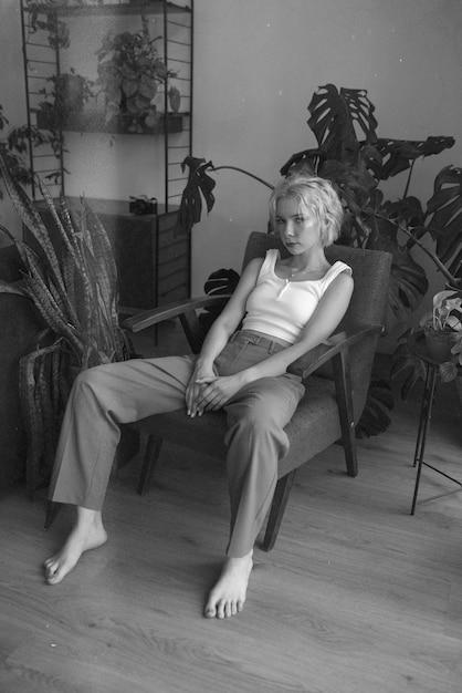 Бесплатное фото Женщина позирует на стуле черно-белый полный кадр