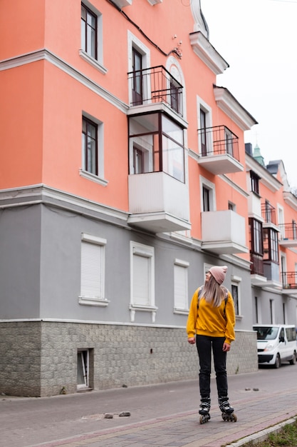 Free photo woman posing in roller blades next to buildings