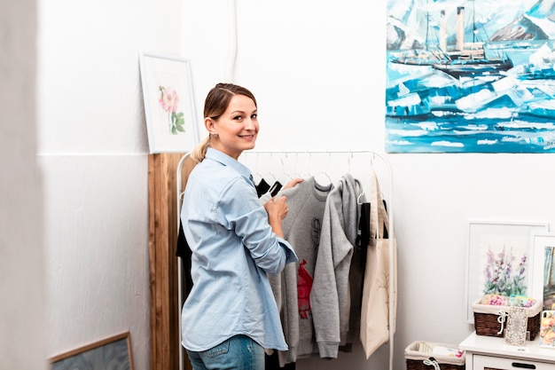 Woman posing and smiling with clothes