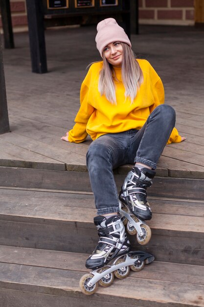 Free photo woman posing on stairs with roller blades