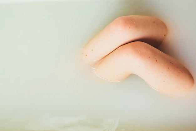 Woman posing in water of bathtub