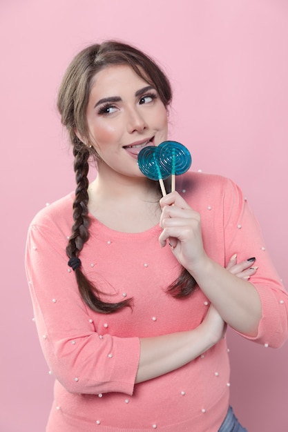 Free photo woman posing while biting lollipops