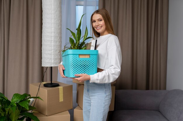 Woman posing while holding a box of belongings