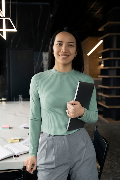 Woman posing while holding a clipboard with documents