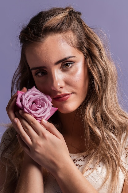 Woman posing while holding a rose