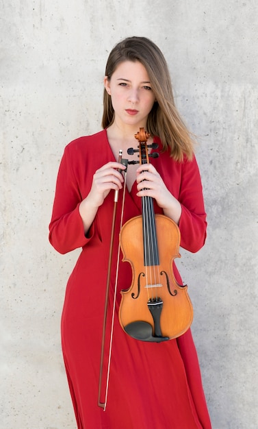Foto gratuita donna che posa tenendo violino e arco