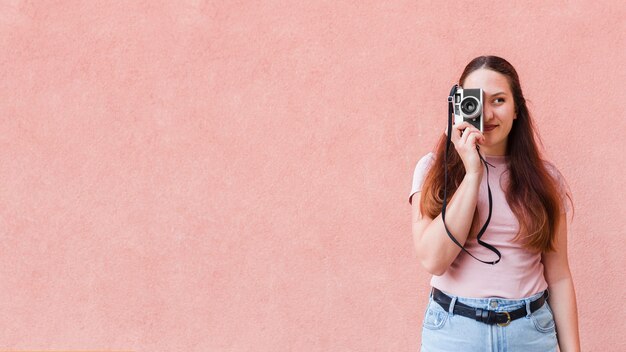 Woman posing while taking a picture with camera