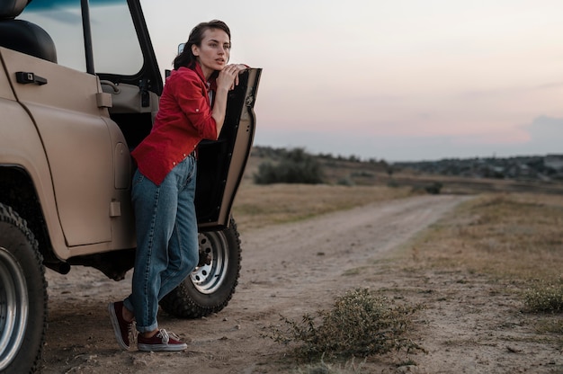 車で一人旅しながらポーズをとる女性