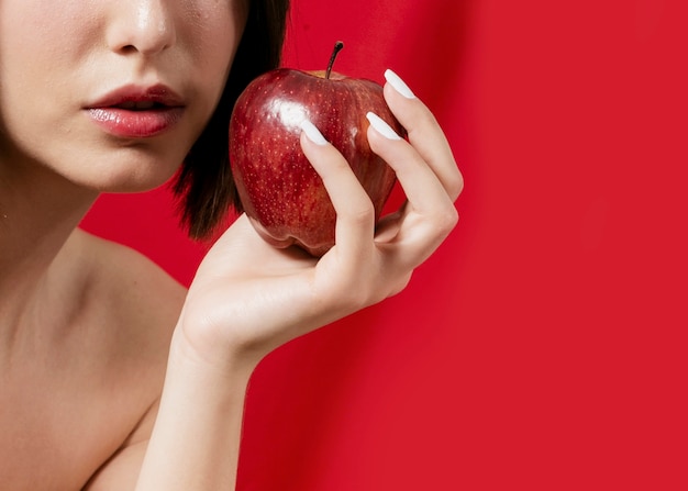 Woman posing with apple close to mouth