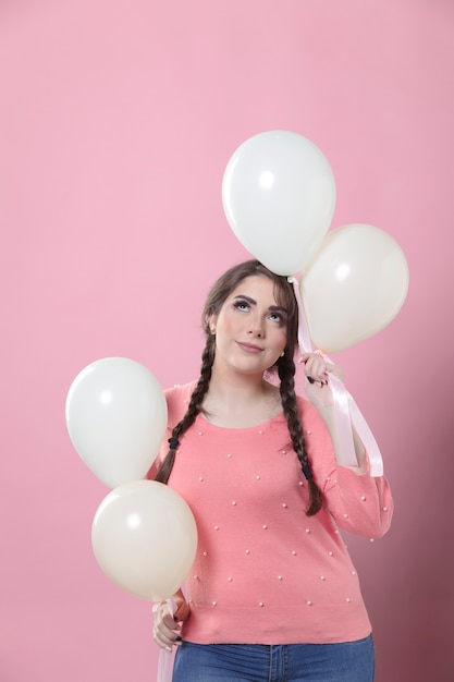 Woman posing with balloons while looking up