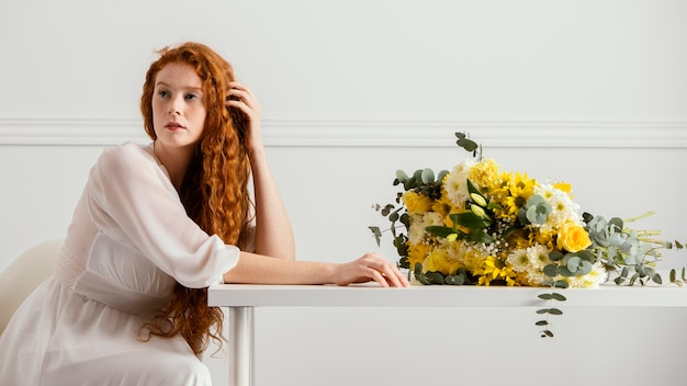 Бесплатное фото Женщина позирует с букетом весенних цветов