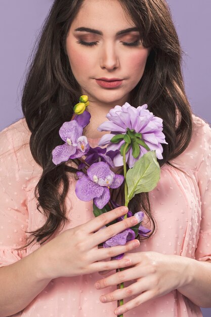 Woman posing with bouquet of orchids and dahlia