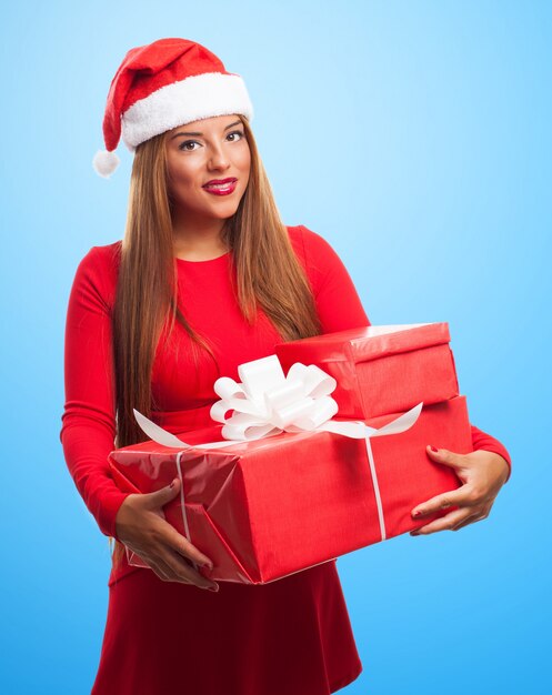 Женщина позирует с рождественские подарки на синем фоне