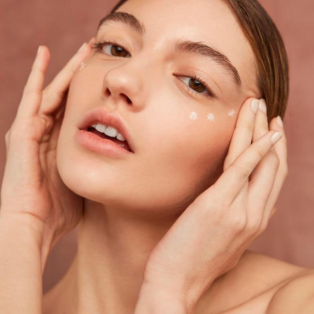 Woman posing with face cream close up