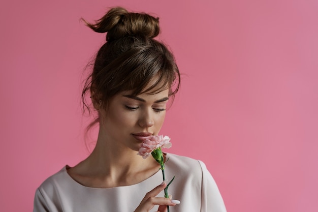 Foto gratuita donna che posa con la vista frontale del fiore