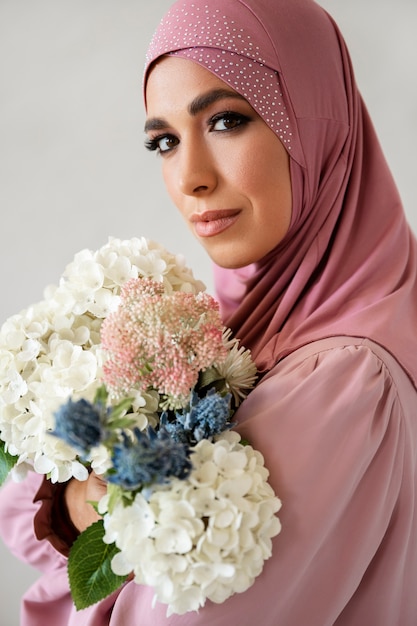 Free photo woman posing with flowers side view