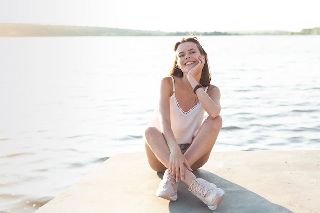 Woman posing with her eyes closed next to a lake