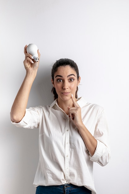 Woman posing with light bulb and copy space